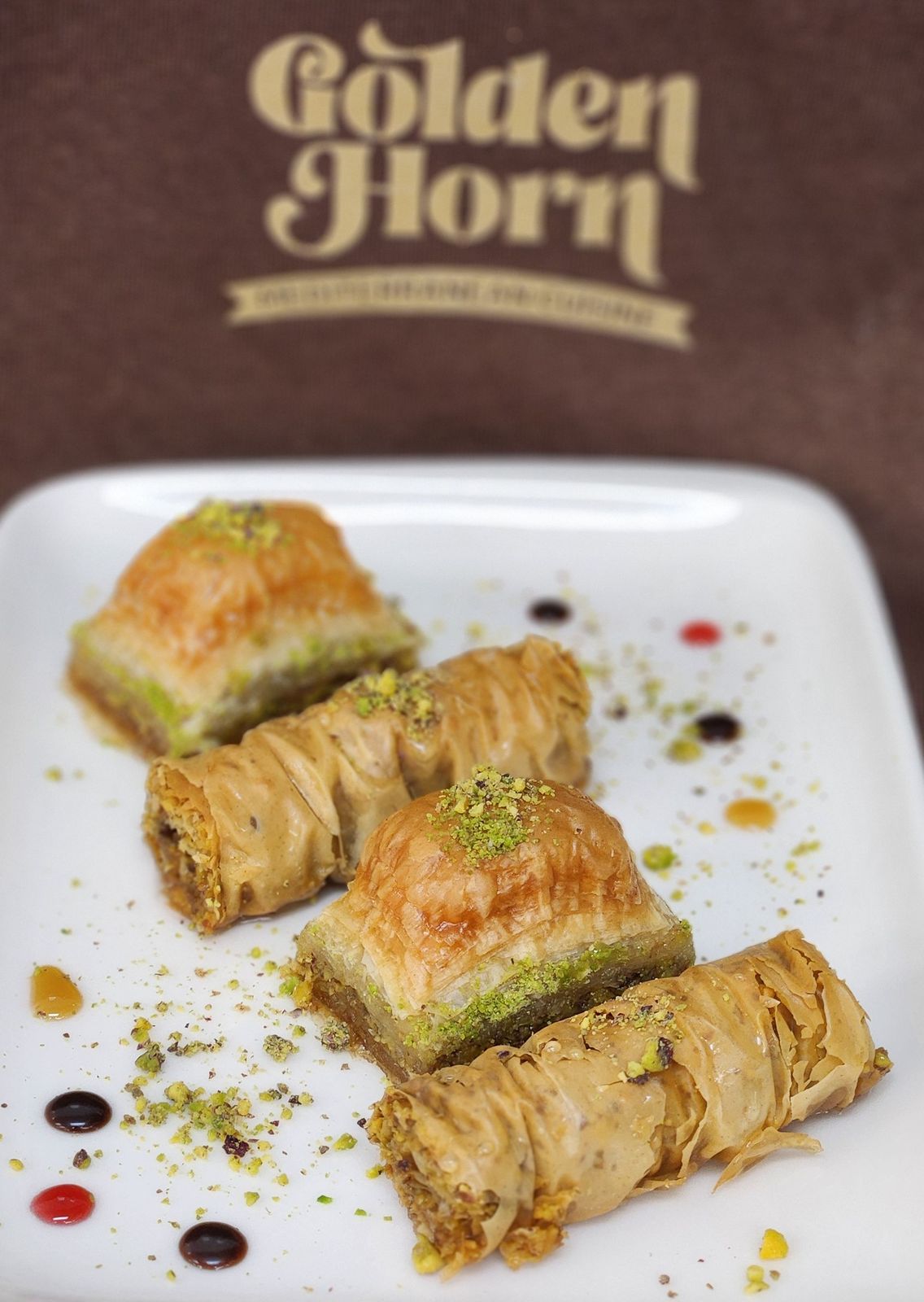 Baklava, squares and rolls, with crushed pistachio
