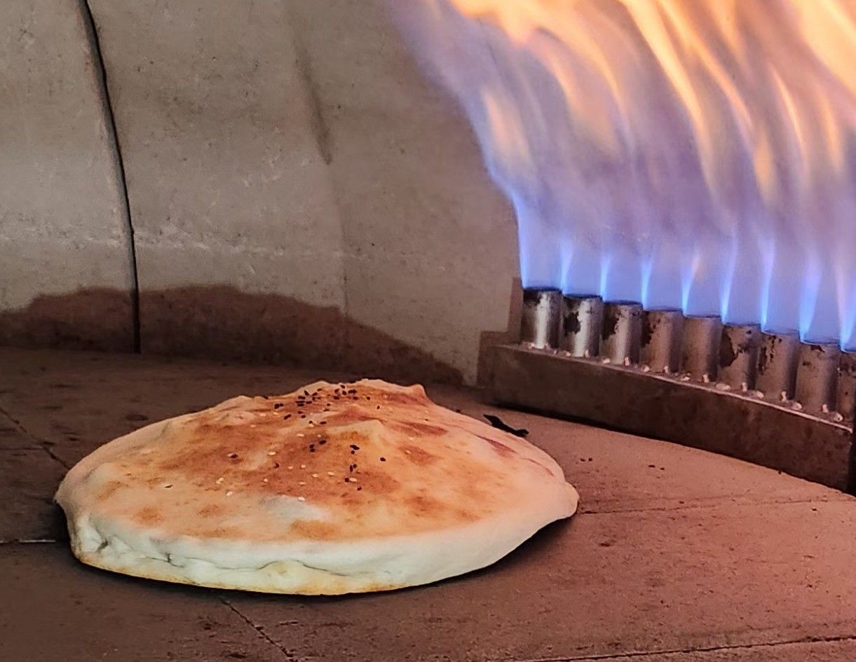 Bread puffing up in the oven next to the flames