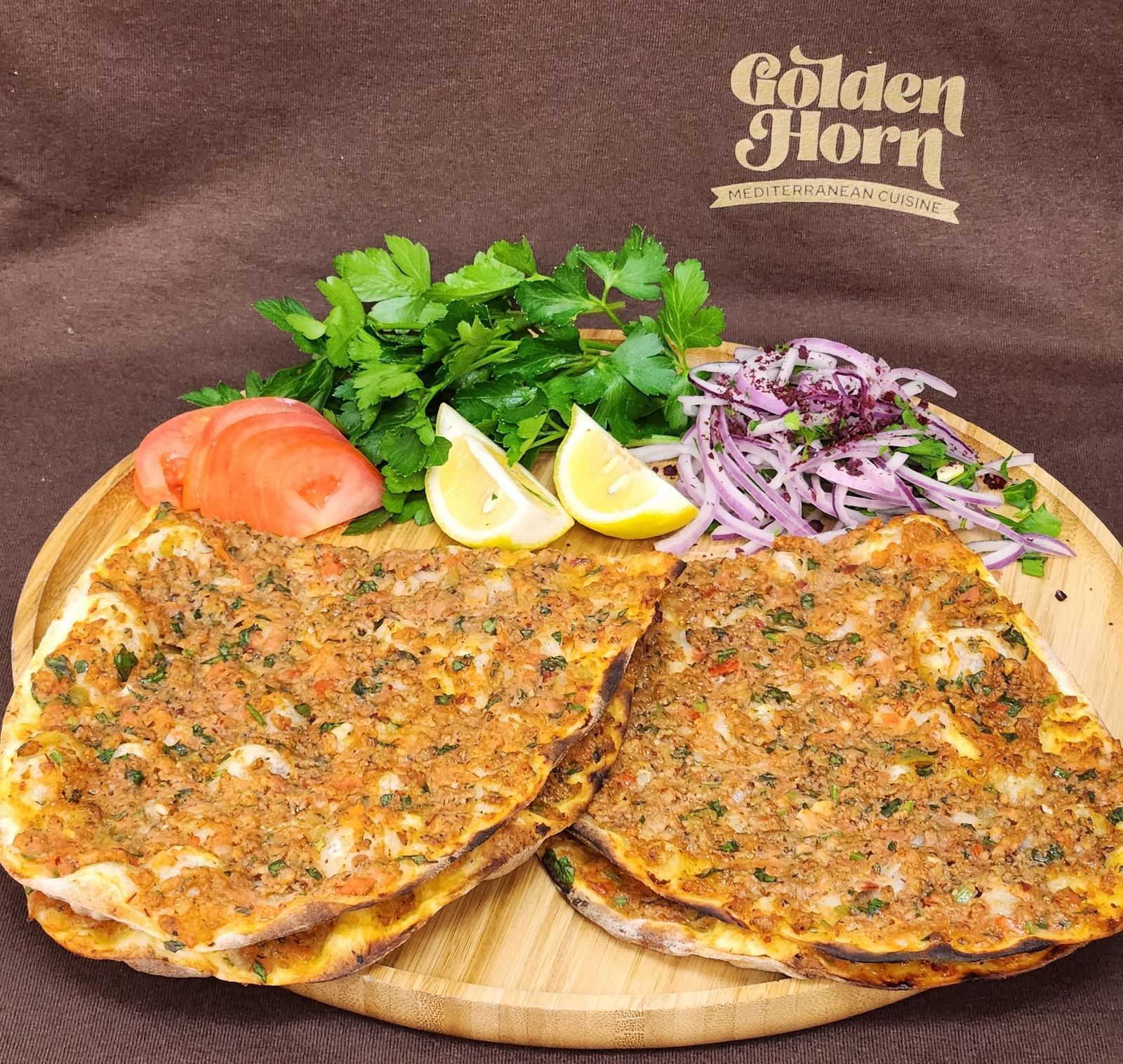 Two lahmacun with onion, parsley and lemon