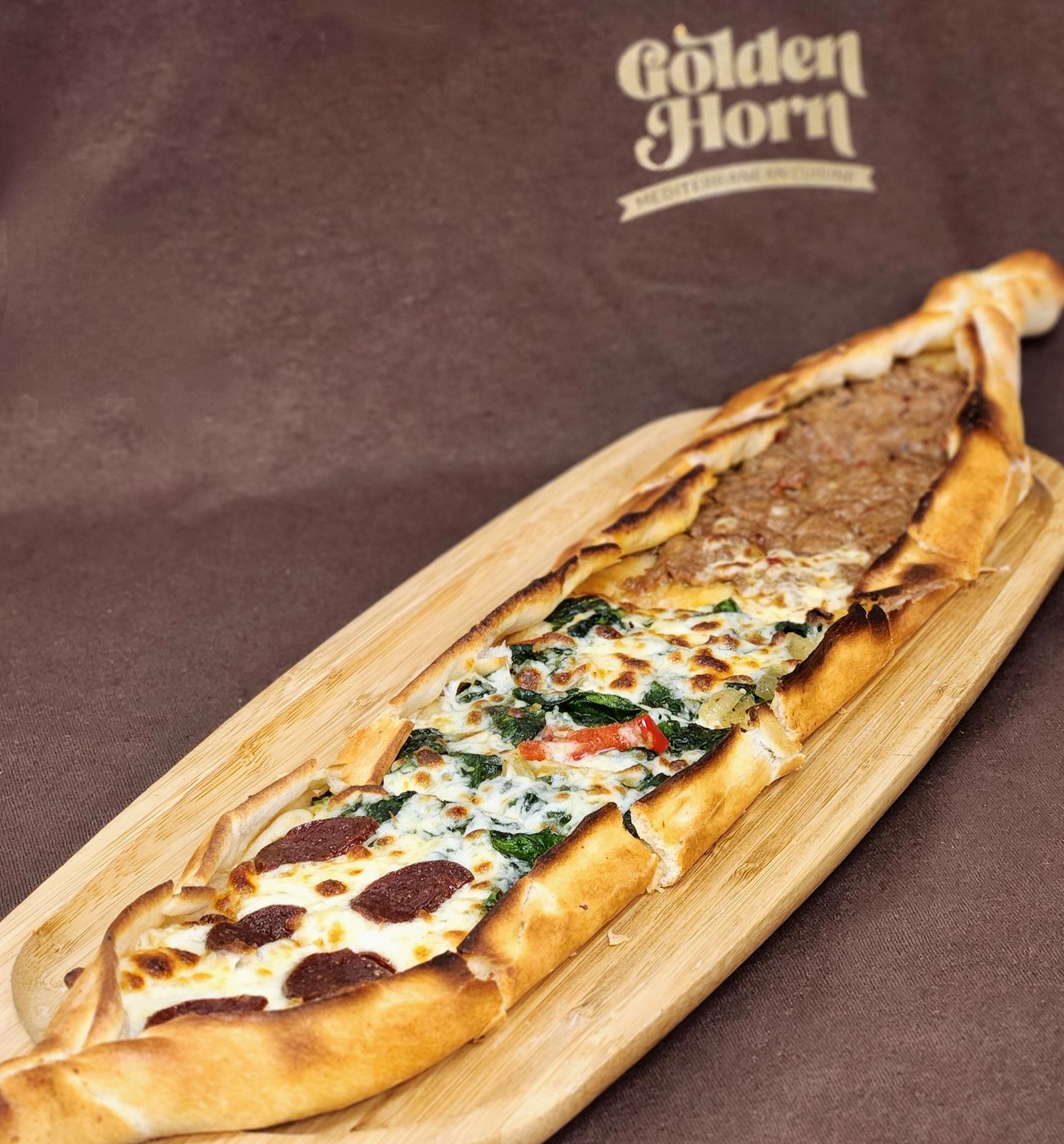 Mix pide with sausage, spinach and ground lamb