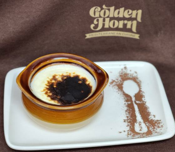 A baked pudding with a browned top in a clay dish