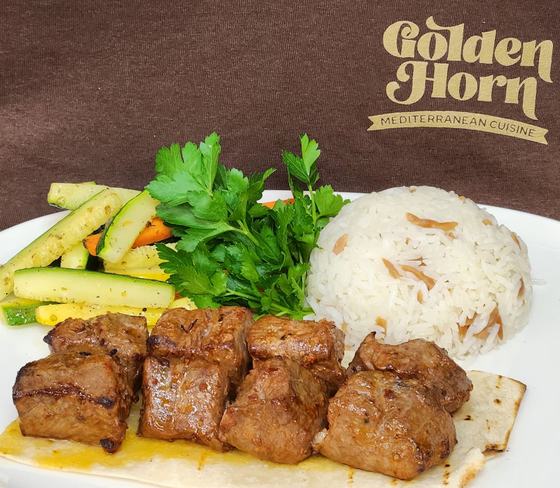 Cubes of grilled meat with rice and vegetables