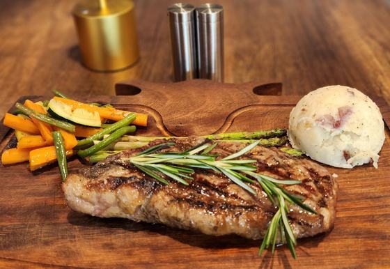 A grilled steak with mashed potatoes and vegetables
