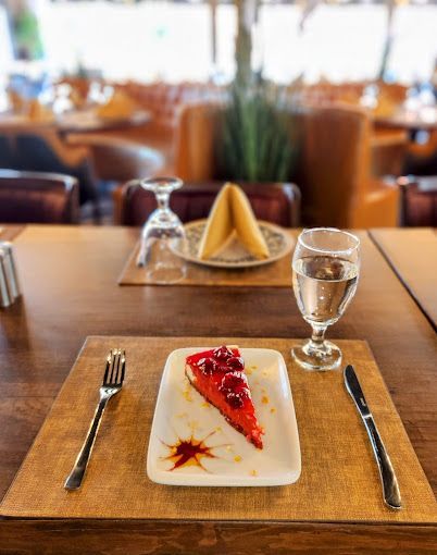 A slice of berry cheesecake at a set table